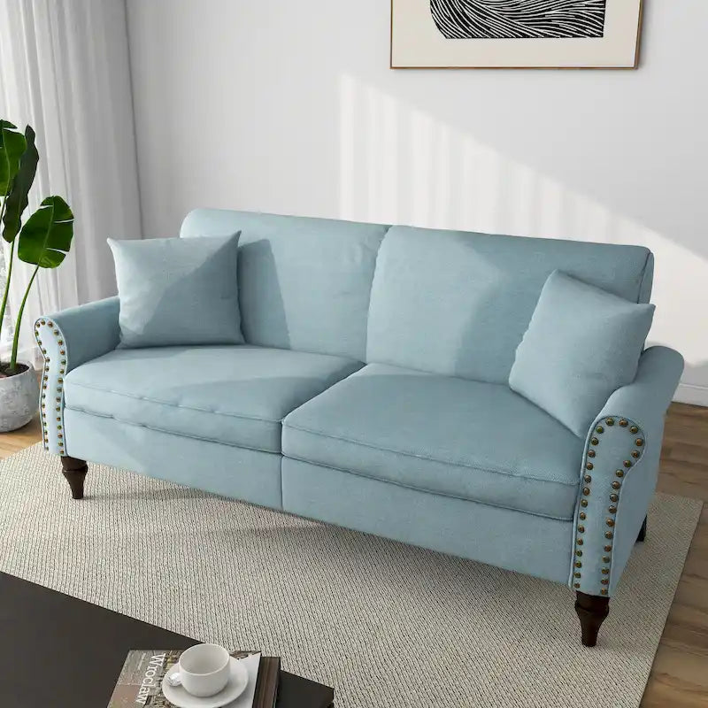 Divano con braccioli arrotondati e finiture con borchie