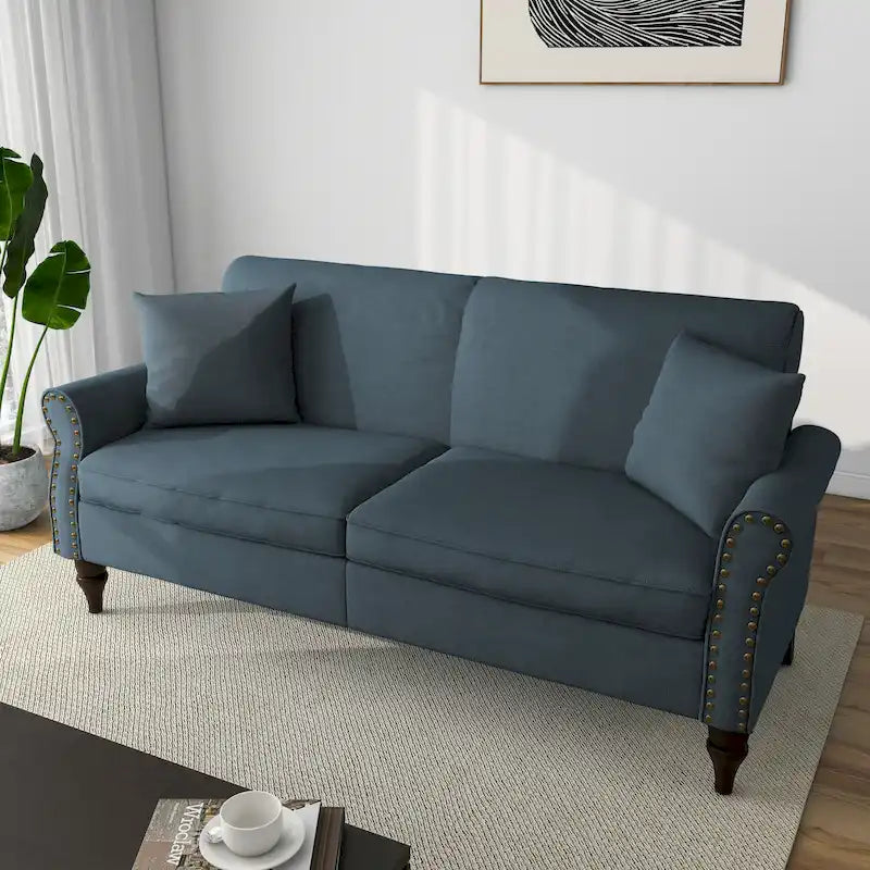 Divano con braccioli arrotondati e finiture con borchie
